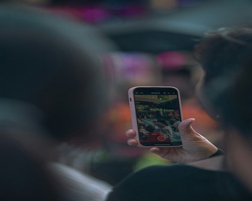 Smartphone displaying a fictional mobile game at an Australian gaming technology exhibition